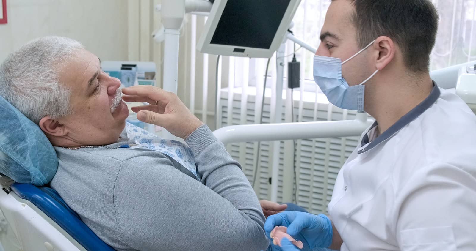 Person at dentist, evaluating best options for dentures