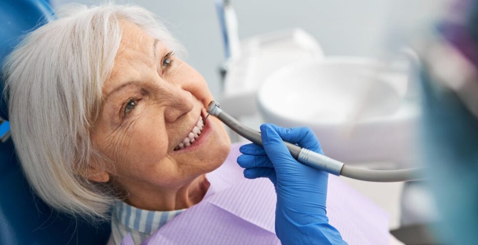 Elderly person at the dentist office, having their teeth examined.