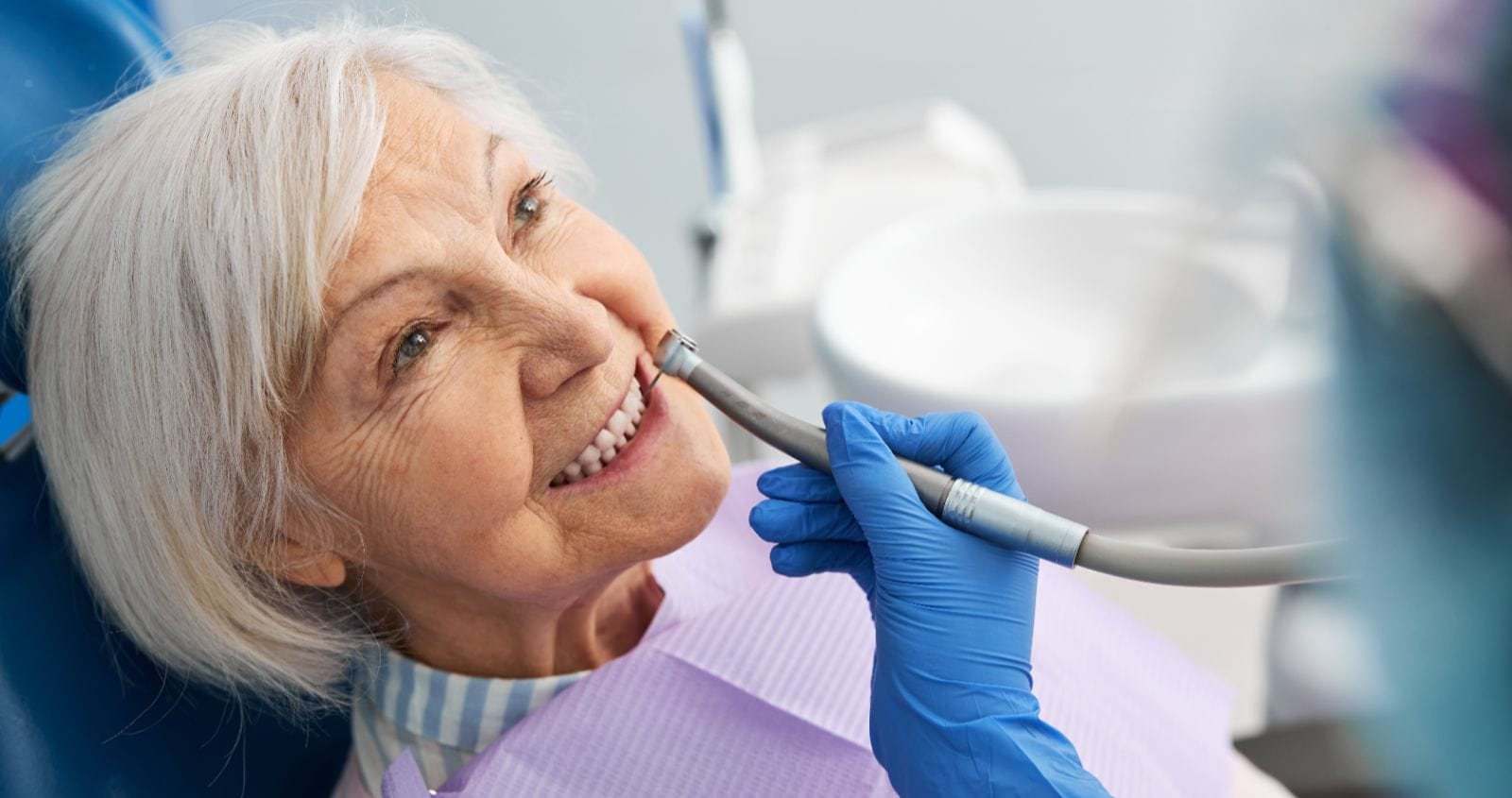 Elderly person at the dentist office, having their teeth examined.