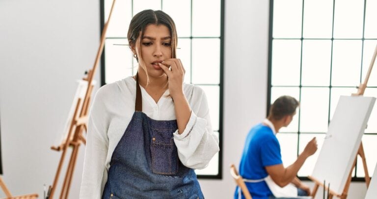 Person biting on nails, possible causing damage to their teeth.