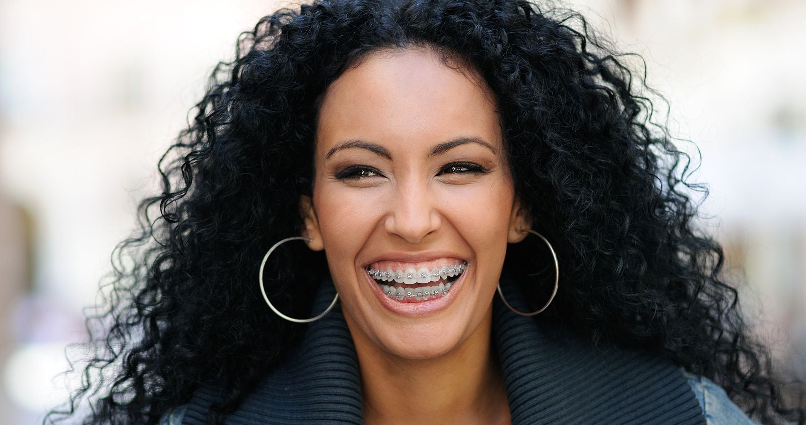 woman smiling with metal braces on teeth.