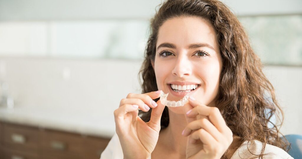 A person about to put their invisalign braces in.