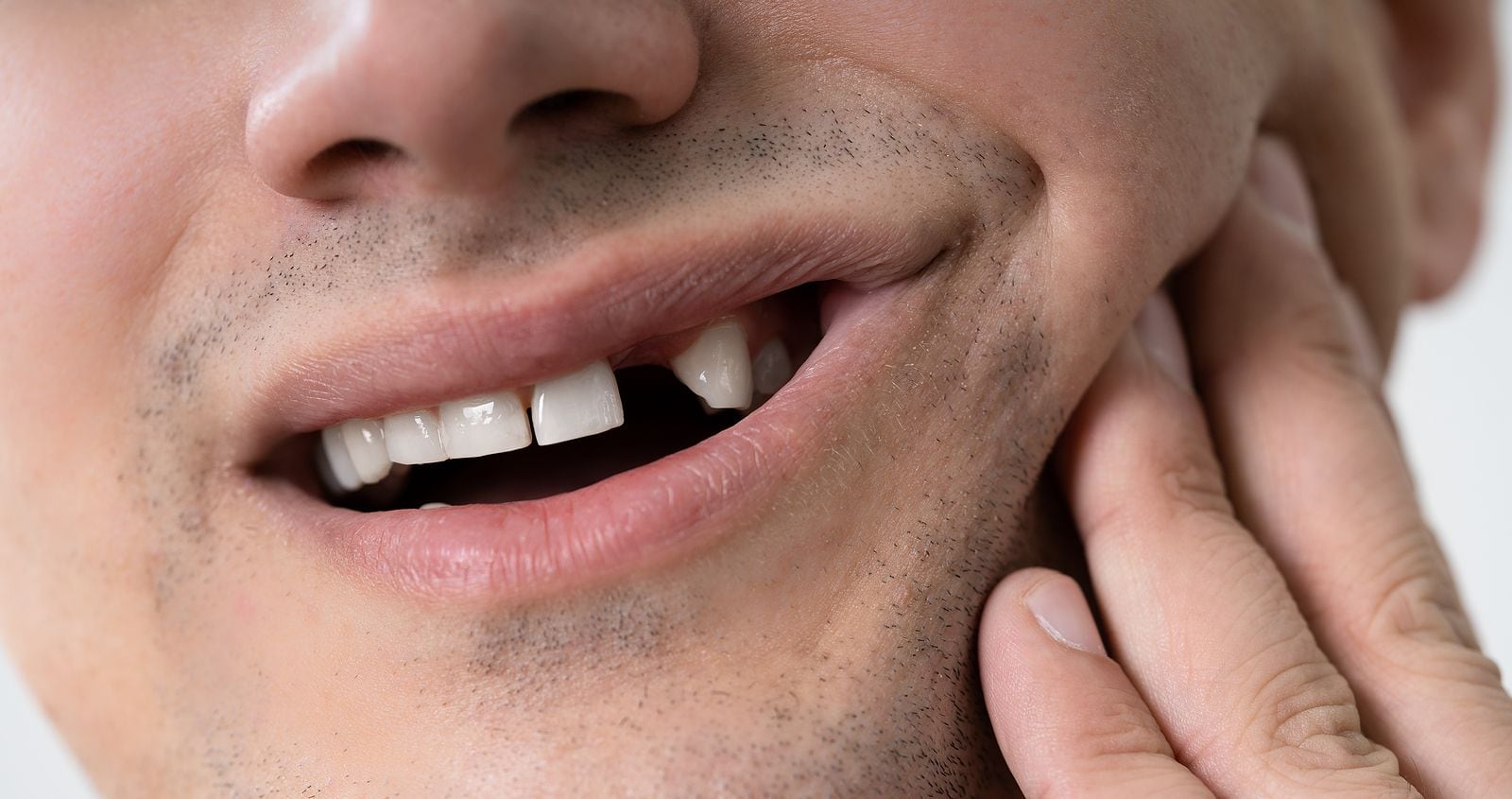 Man with missing tooth experiencing jaw pain.